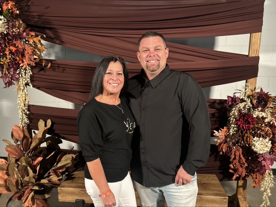 Two people smiling together at a community event